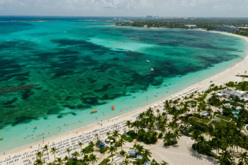 Aerial view of a white sand beach and turquoise reef