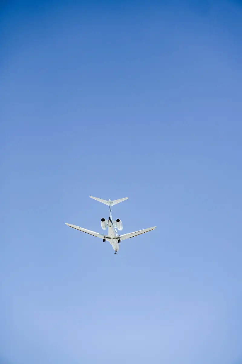 Private jet climbing into a clear blue sky