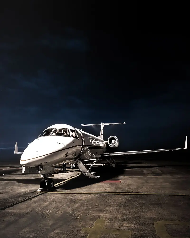 Placeholder photo of a private jet lit on a ramp at night